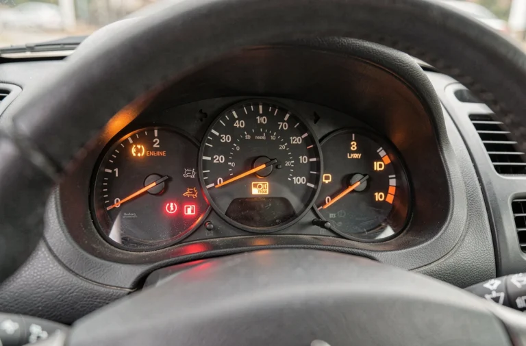Tableau de bord d'une Peugeot 206 avec voyants d'alerte allumés, vue rapprochée du combiné d'instruments